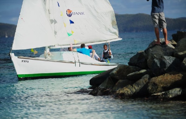Thad Lettsome carries the Queen's Baton onboard Intrepid Credit: Todd vanSickle/BVI Spring Regatta