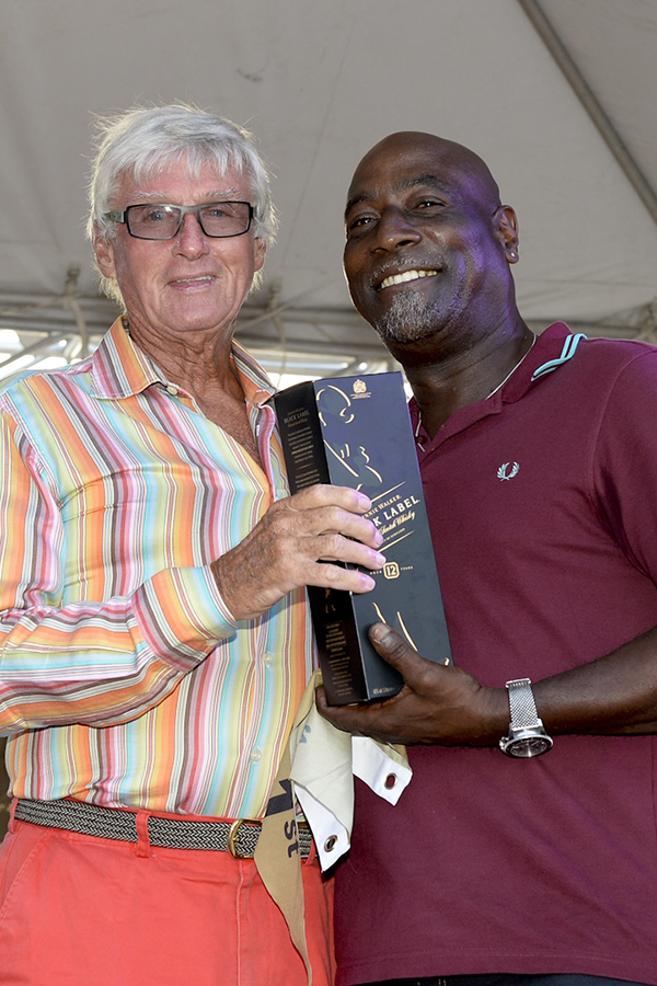 Two veteran sporting icons from Antigua: Sir Viv Richards presents Biwi Magic owner, Geoffrey Pidduck with Johnnie Walker prizes for first place on the Johnnie Walker Race Day 2 at Antigua Sailing Week - Credit: Ted Martin/Photofantasyantigua.com
